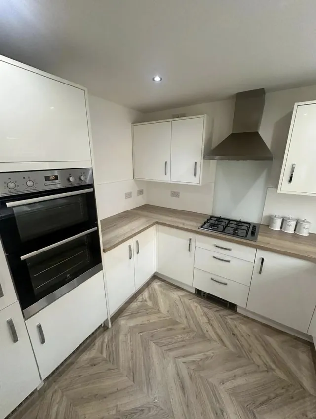 Fitted white kitchen with herringbone floor