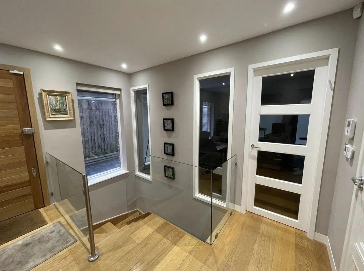 Oak staircase landing with glass balustrade